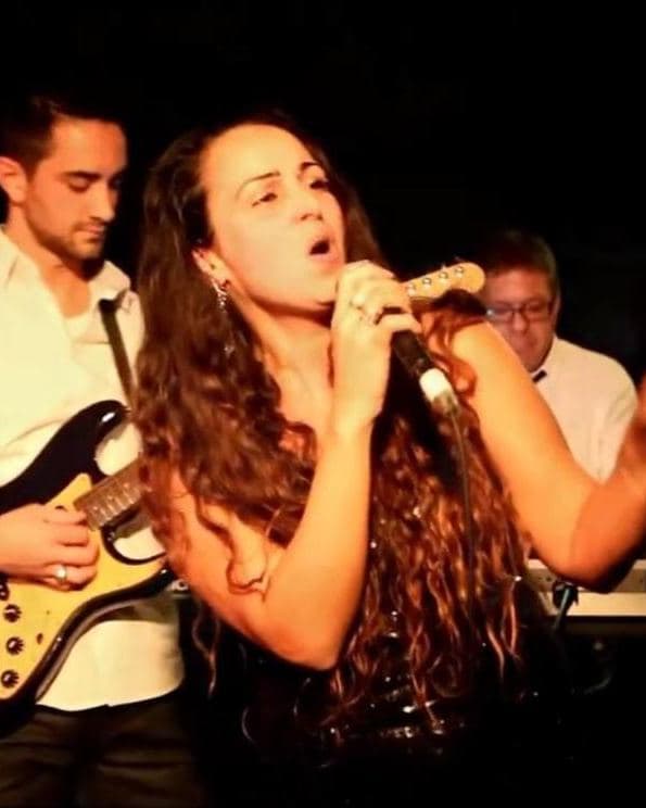 Sharon Kaniel singing on stage with a band